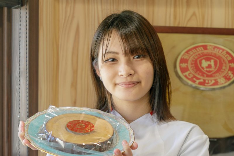 バウムクーヘンを手に持つチロリア八鹿店の店員